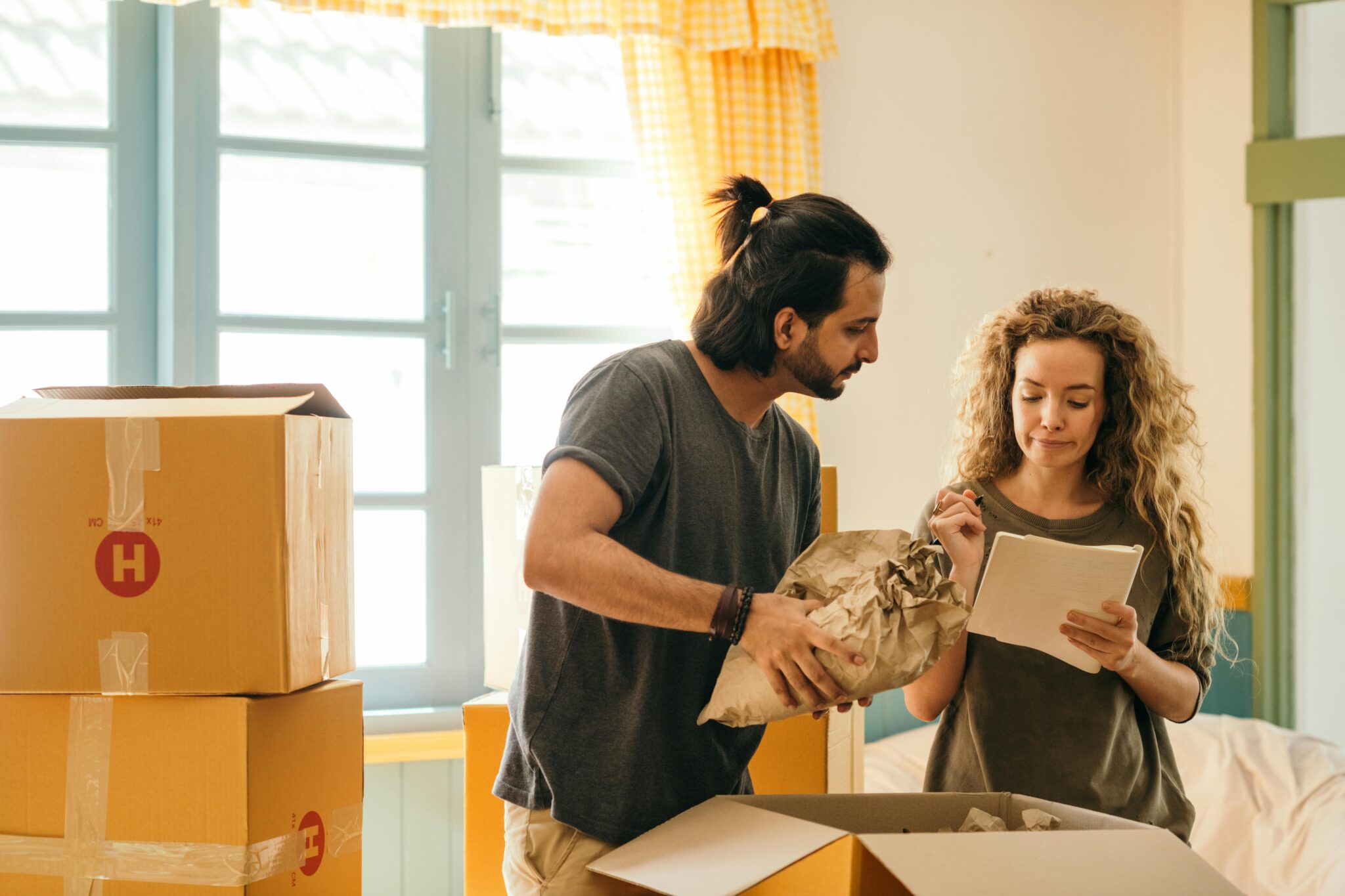 Man and Woman Signing Documents while Unpacking Things